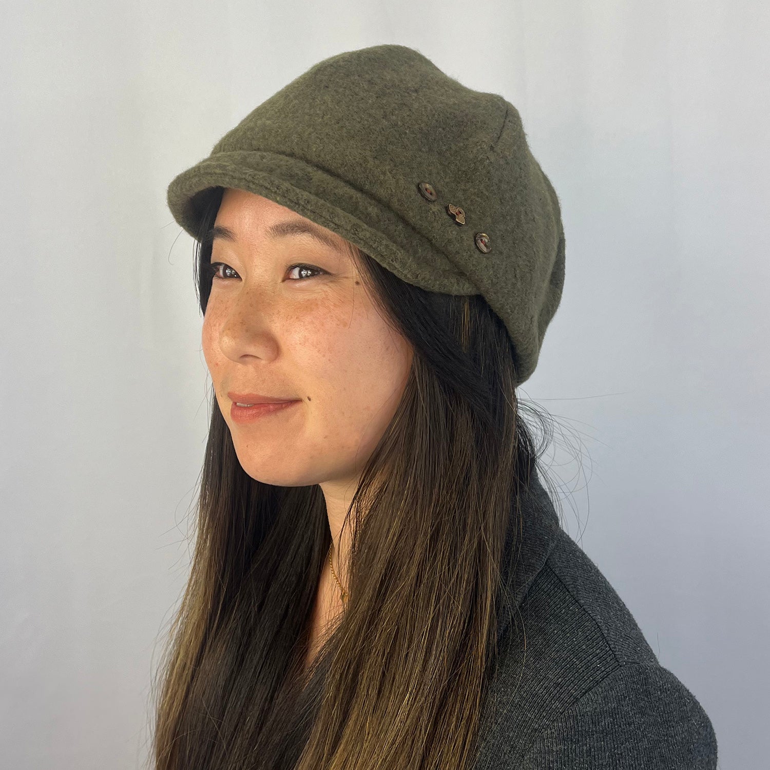 Woman wearing a green cap against a plain background g-and-l-positive-goods-camden-cap