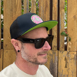 La Playa Green Flash Trucker Hat on male model, profile view – recycled vintage patch mesh cap