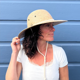 Female model wearing Anya Palm Straw Sun Hat, featuring wide brim sun protection and adjustable strap.