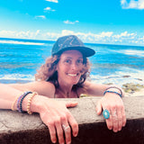 Female model wearing the Visions Cosmos Trucker Hat, showcasing sustainable materials and cosmic style.