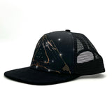 Side profile of the Visions Cosmos Trucker Hat with breathable mesh, recycled fabric, and structured low-profile design.