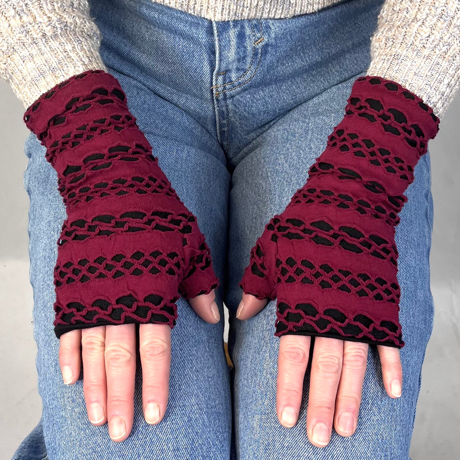 Aspen Wrist Warmers on female model – upcycled knit wrist warmers - burgundy gloves with black cut outs
