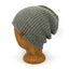A textured knit slouchy beanie in a heathered gray-green color, displayed on a wooden mannequin head against a white background.
