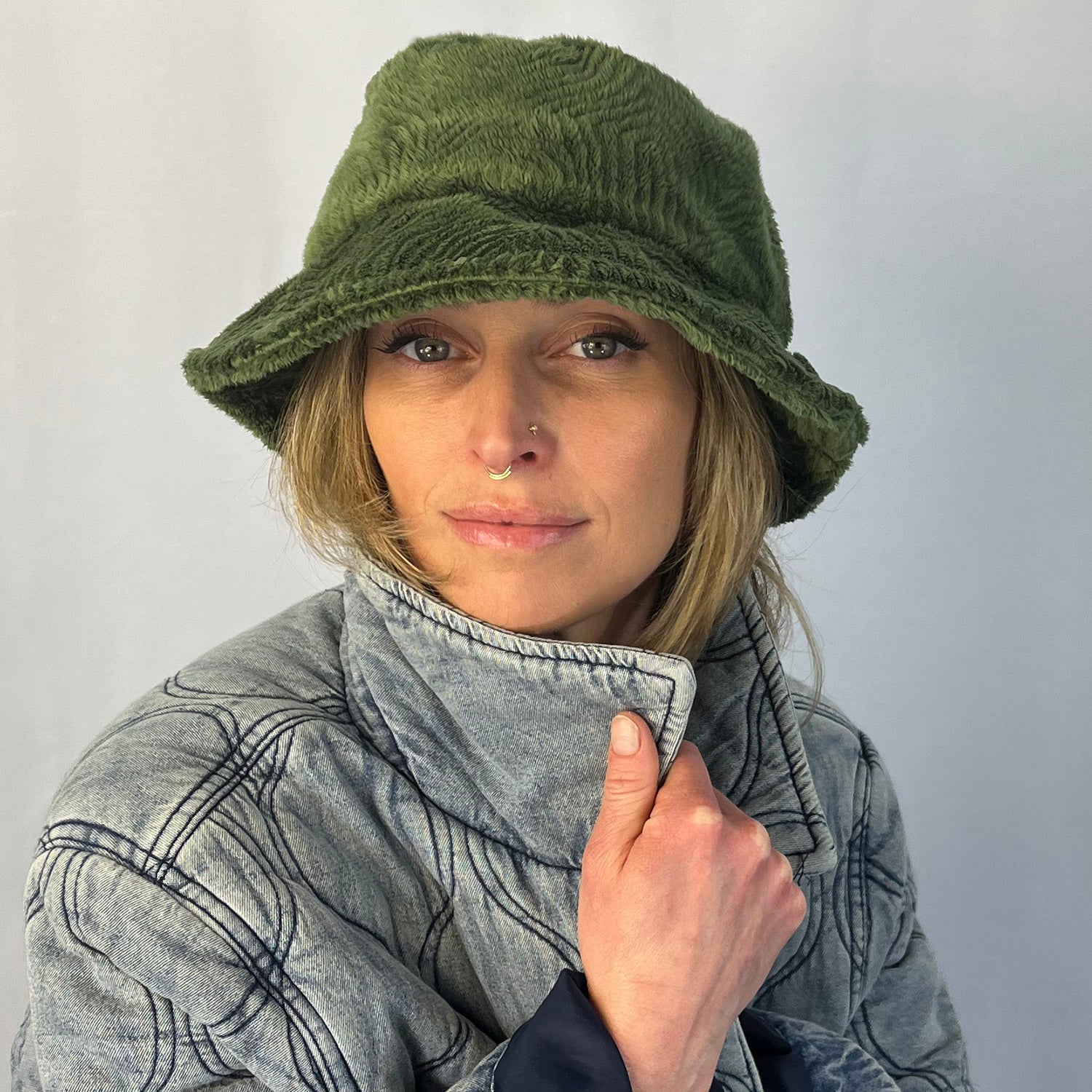 Woman wearing a green bucket hat and gray coat against a plain background   Polar Fleece fabricl – upcycled unisex winter hat