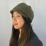 Woman wearing a green cap against a plain background g-and-l-positive-goods-camden-cap