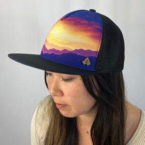 Horizon Gratitude Trucker Hat three-quarter view on female model – recycled breathable cap with Jeff Stanley landscape design