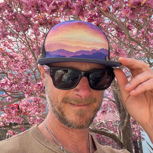 Horizon Gratitude Trucker Hat front view on male model – Fair Trade nature art summer trucker hat