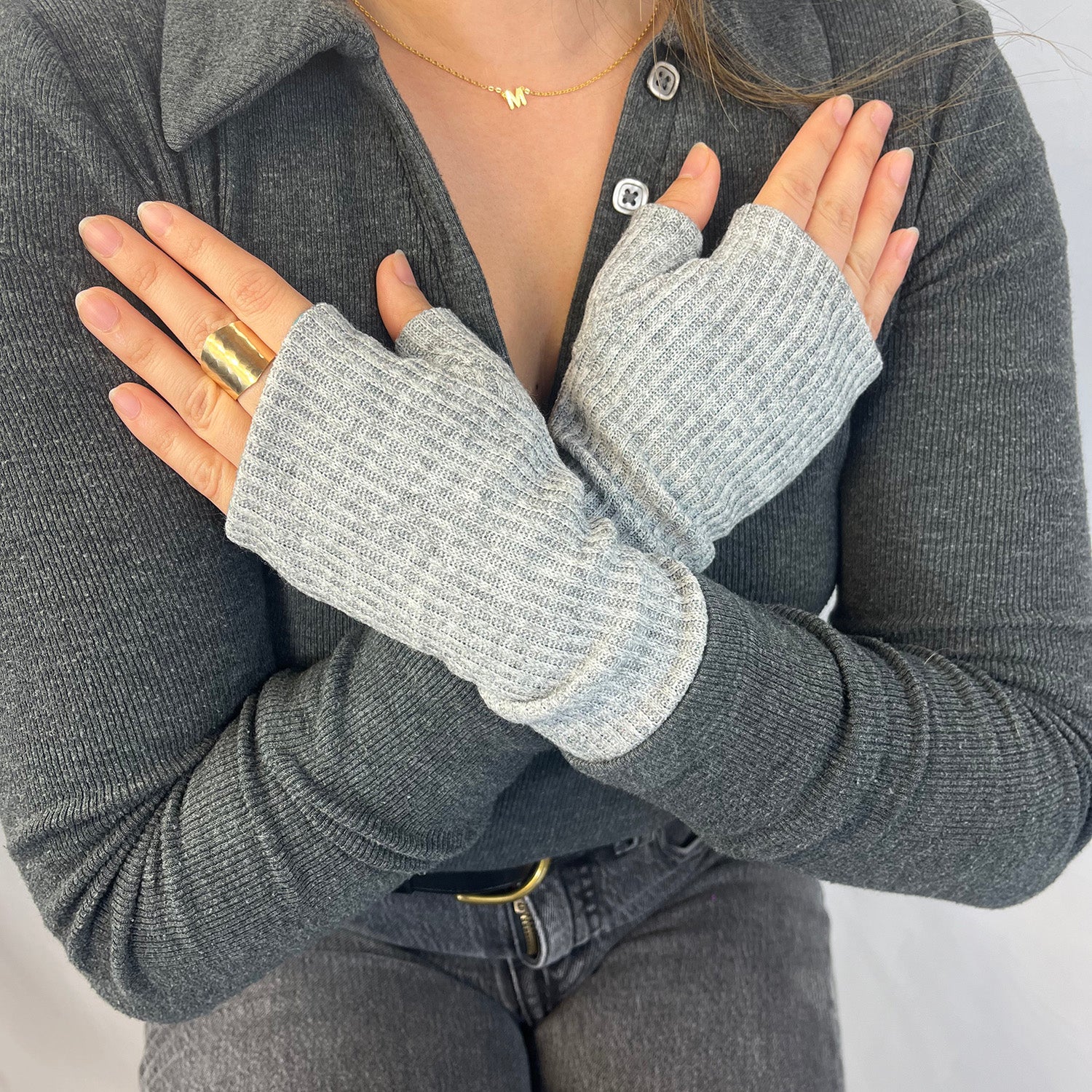Kenzie wristwarmers front view – upcycled rib knit sustainable accessory. Person wearing gray fingerless gloves with a neutral background