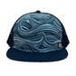 Front view of the Waves Silver Trucker Hat with ocean wave print, breathable mesh back, and adjustable snap closure.