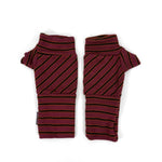 A pair of wristwarmers with diagonal dark stripes on a burgundy base, laid flat on a white background.