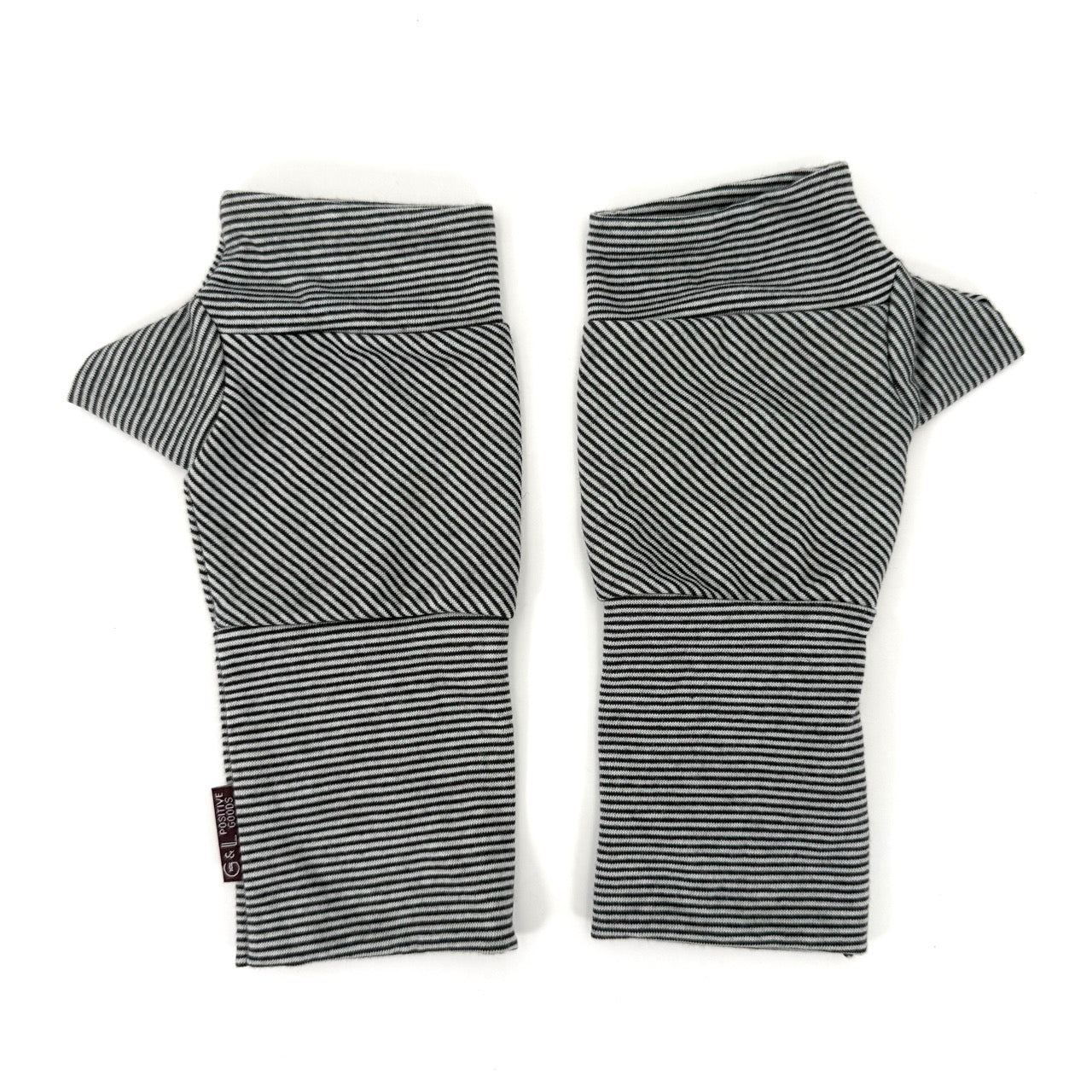 A pair of knit fingerless gloves with horizontal black and white stripes, laid flat on a white background.