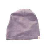A light purple knit beanie hat with a small beige tag on the side, photographed against a plain white background.