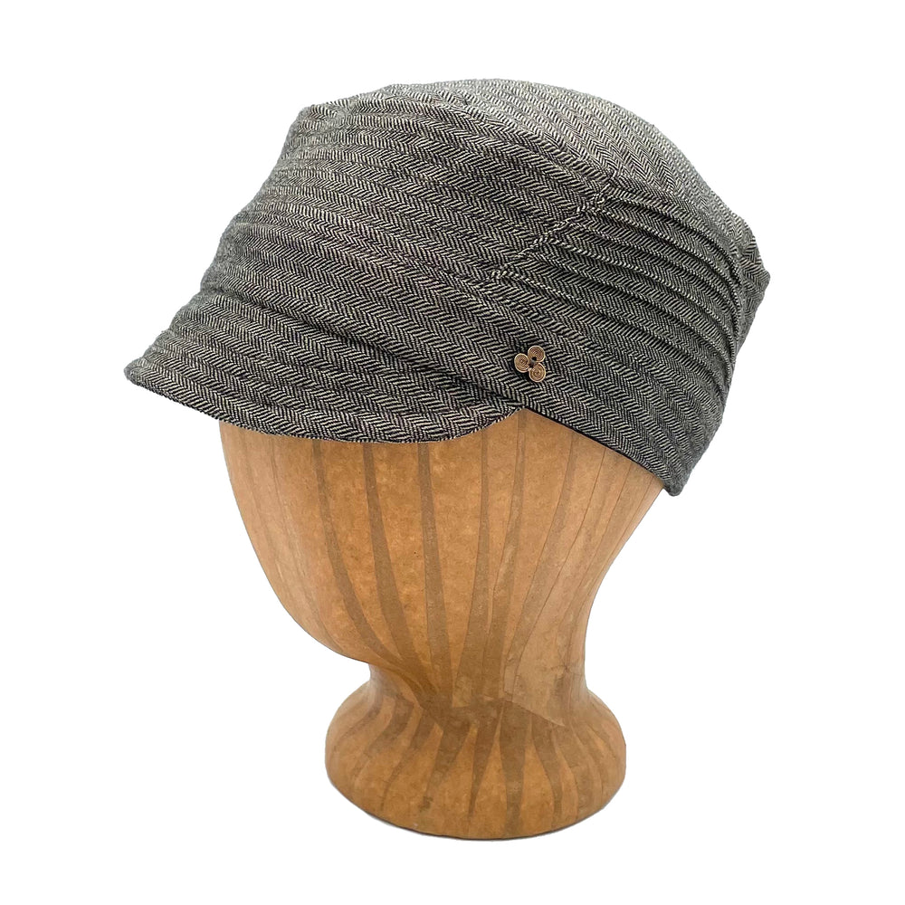 Art Soft Cap in grey herringbone color profile angle on wooden head block – soft cap with coconut button and elastic back
