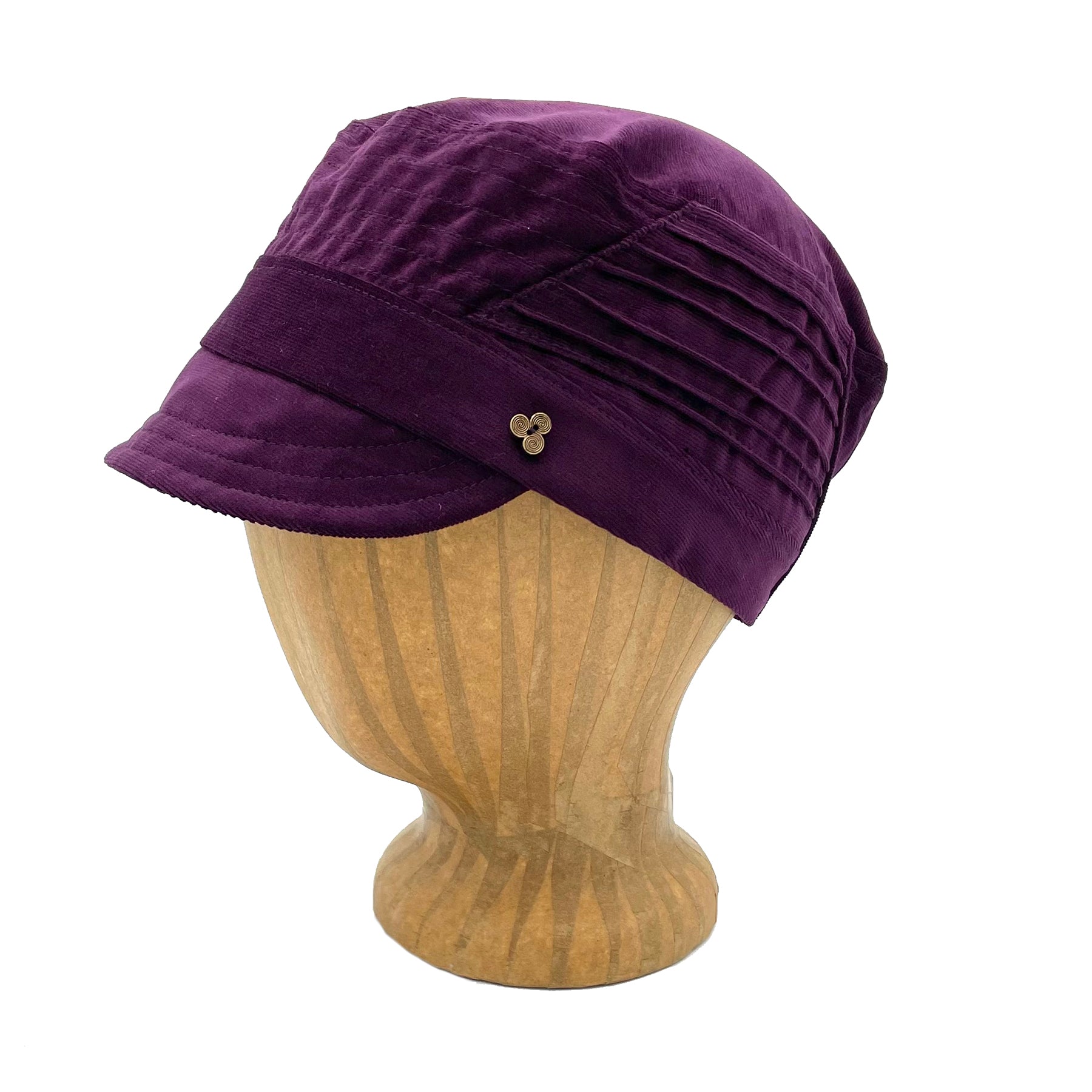 Art Soft Cap in purple corduroy color profile angle on wooden head block – soft cap with coconut button and elastic back