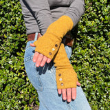 Coco Wrist Warmers in yellow dijon color on female model front view– bohemian sustainable gloves
