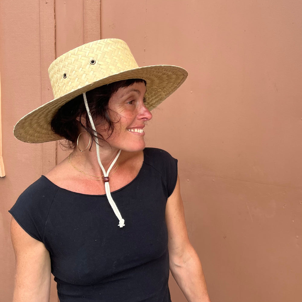 Female model wearing Cordoba Palm Straw Sun Hat, showcasing sun protection and stylish natural straw.