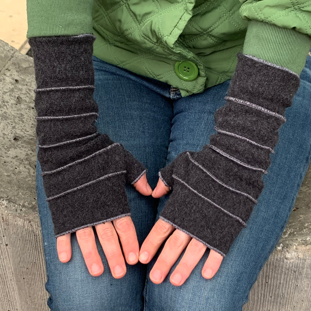 Crossroads Wrist Warmers in charcoal color – female model wearing recycled wrist warmers