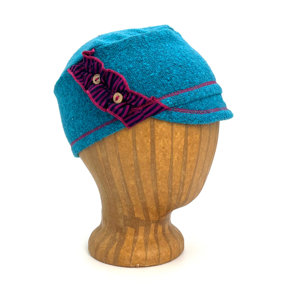 Dalhia Kids Soft Cap in light blue teal, profile angle on wooden head block – soft and adjustable kids cap