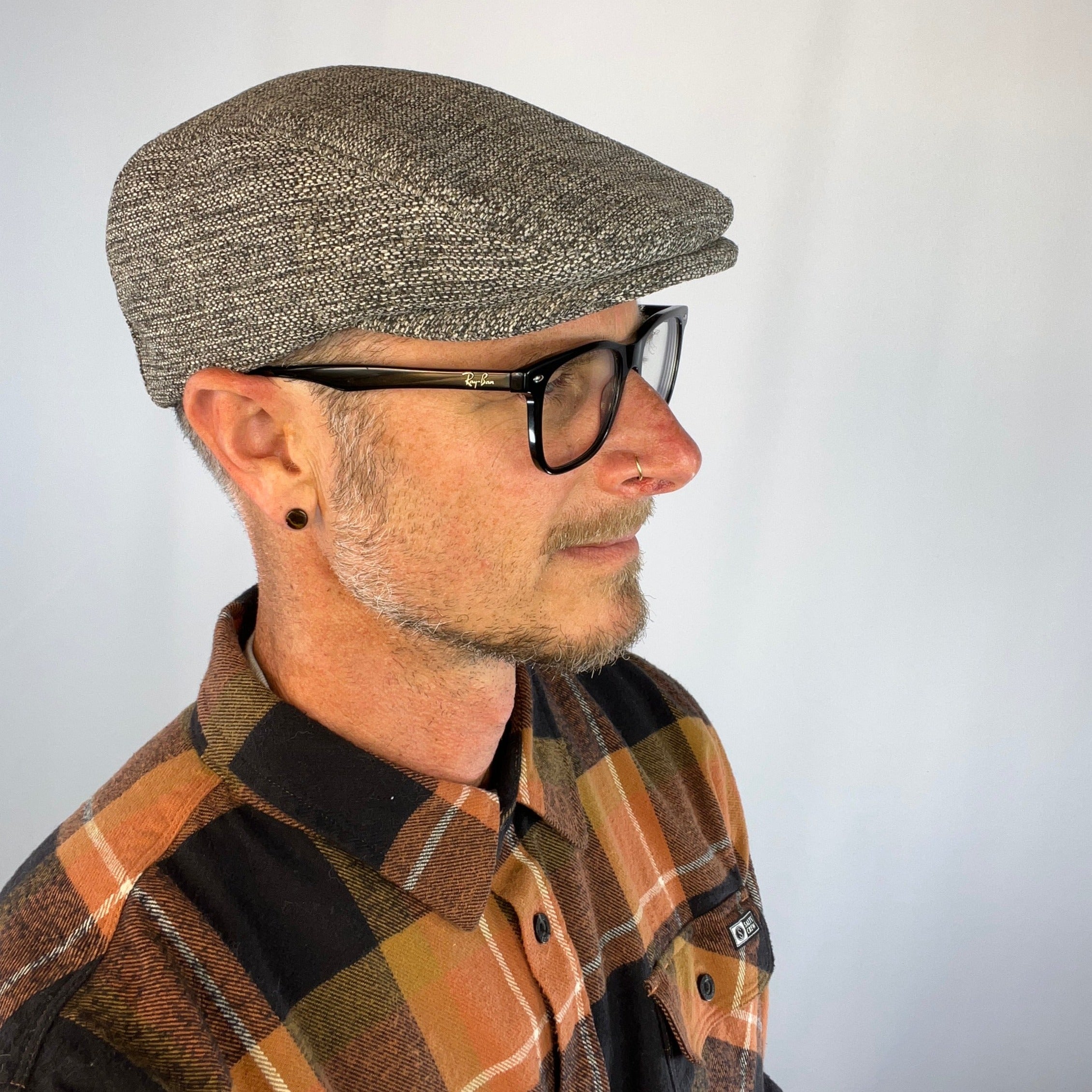 Male model styling the profile of the sustainably made Dublin Flat Cap.