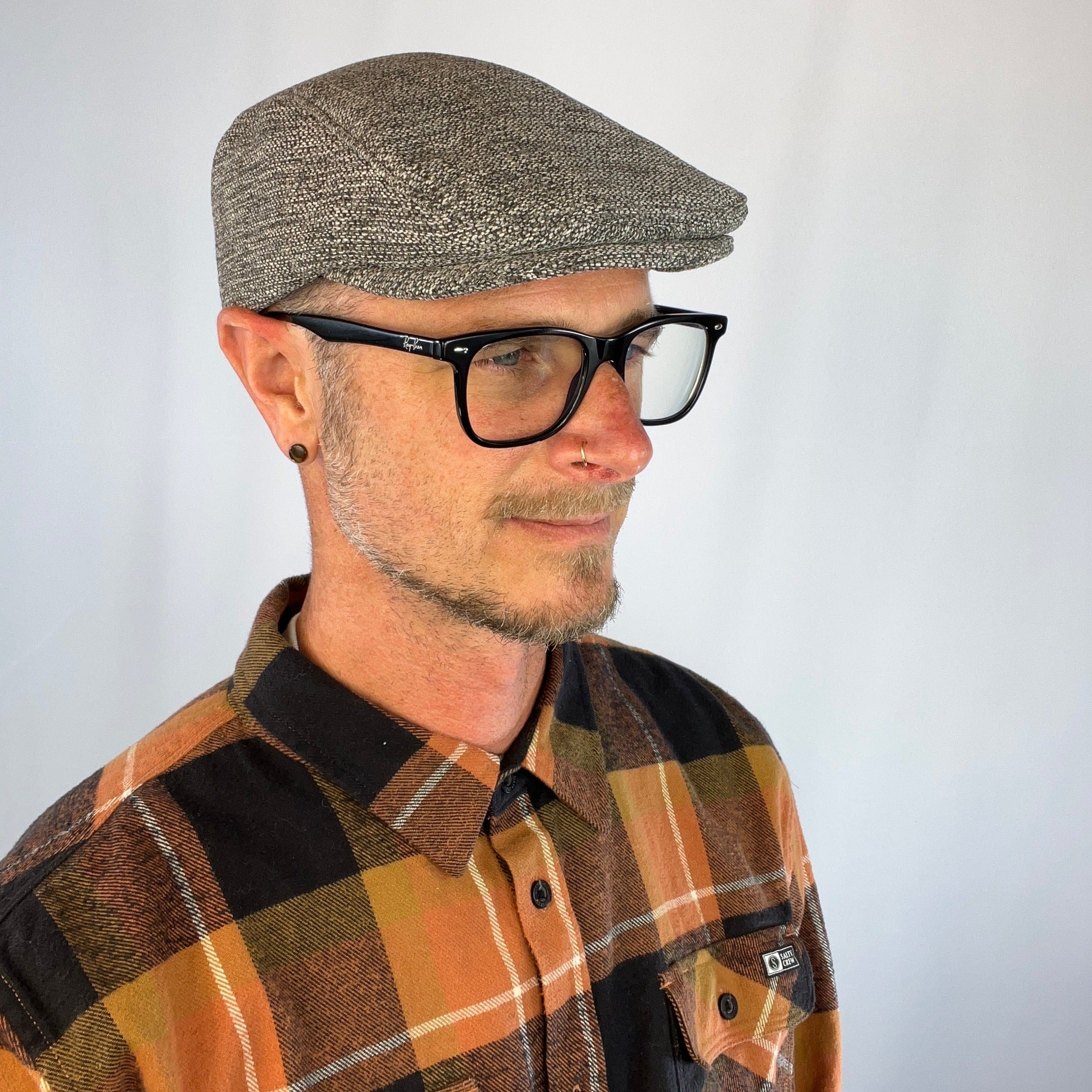 Side profile of male model wearing the Dublin Flat Cap highlighting the cap's sleek shape.