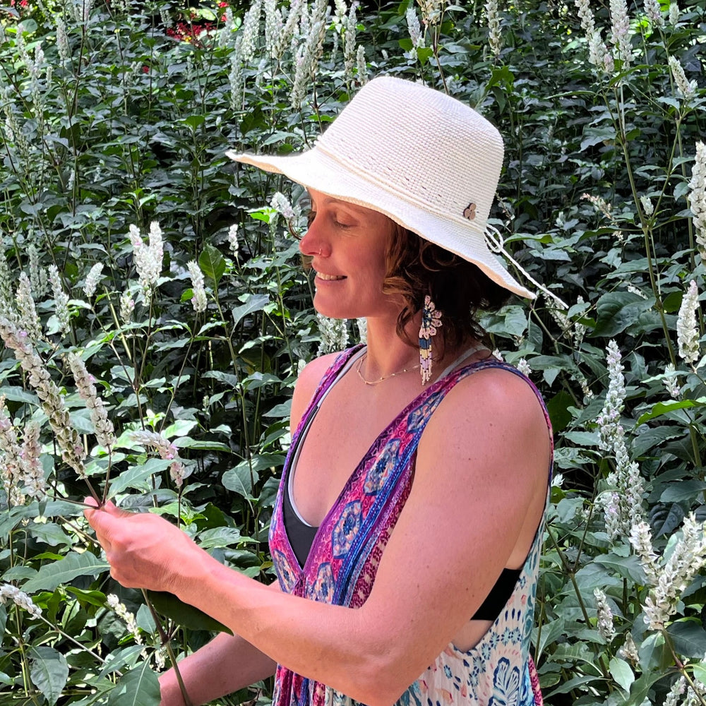 Female model wearing Creme weave Frida Toyo Straw Sun Hat, showcasing wide brim and sustainable crochet design.