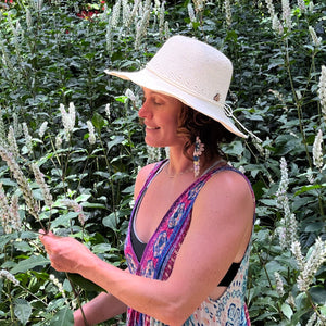 Female model wearing Creme weave Frida Toyo Straw Sun Hat, showcasing wide brim and sustainable crochet design.