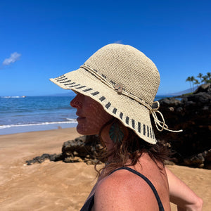 Female model wearing Beach weave Frida Toyo Straw Sun Hat, showcasing wide brim and sustainable crochet design.
