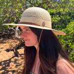 Female model wearing Hana Palm Straw Sun Hat, showcasing wide brim and eco-friendly materials.