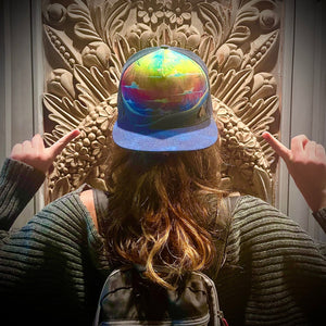 Female model wearing the Horizon Rainbow Trucker Hat, showcasing its unisex artistic design and sustainable craftsmanship.