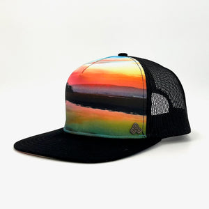 Side profile of the Horizon Trucker Hat, showing its structured fit, eco-friendly materials, and unique sunset photography.