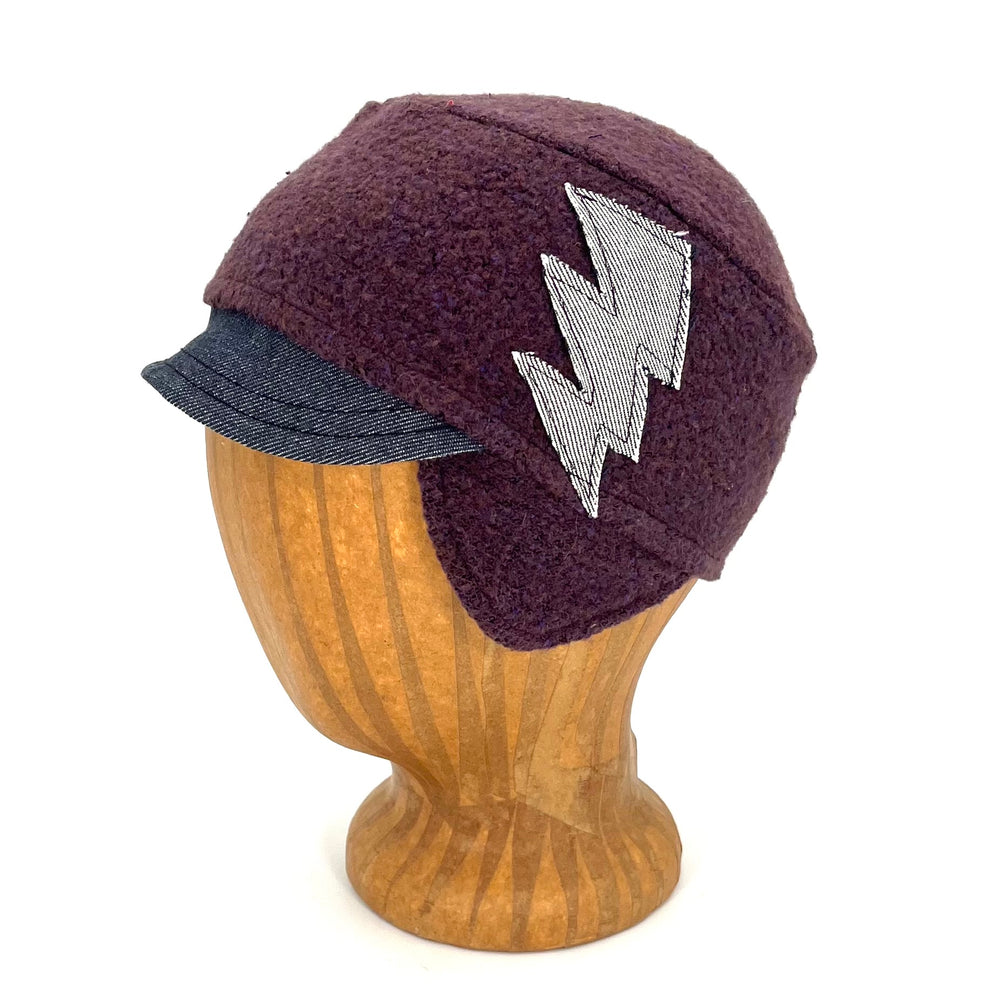 Side view of the Kenji Hat for Kids made from recycled fabric with earflaps and a sewn electric bolt.