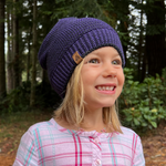 Girl model wearing Kids Bigfoot Beanie in elderberry color – soft, recycled cotton knit