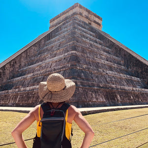 Martinique Sun Hat female model back view outside ziggurat in Mexico, made of grass straw with breathable weave and wood bead band