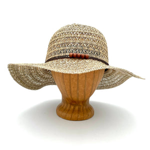 Martinique Sun Hat front view on wooden head block made of grass straw with breathable weave and wood bead band