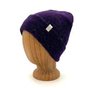 Midnight Beanie in plum color – worn on wooden head block.