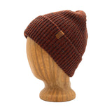 Oaktown Beanie in Rust color – worn on wooden head block.
