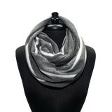 A gray and white striped infinity scarf displayed on a black mannequin torso against a plain white background.