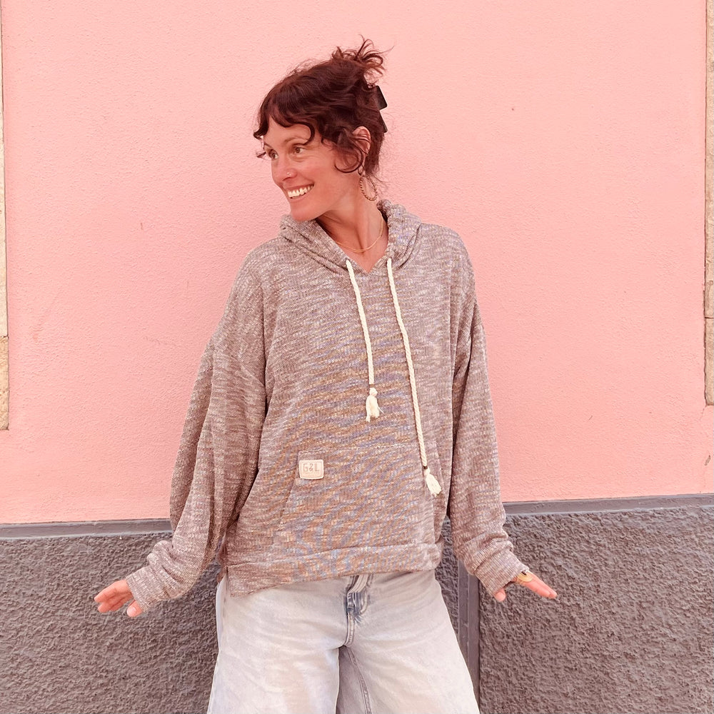 Crop square of female model wearing Sea Breeze Hoodie, showcasing relaxed fit and eco-friendly materials.