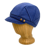 A blue wool cap with a short brim and two brown buttons, displayed on a wooden mannequin head against a white background.