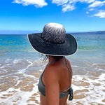 Female model wearing Sonia Sun Hat, back side view zoomed out, with wide brim and coconut button accent