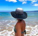 Female model wearing Sonia Sun Hat, back side view zoomed out, with wide brim and coconut button accent
