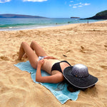 Female model wearing Sonia Sun Hat, back side view zoomed out, with wide brim and coconut button accent