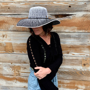 Female model wearing Sonia Sun Hat, three quarter side view zoomed out, with wide brim and coconut button accent
