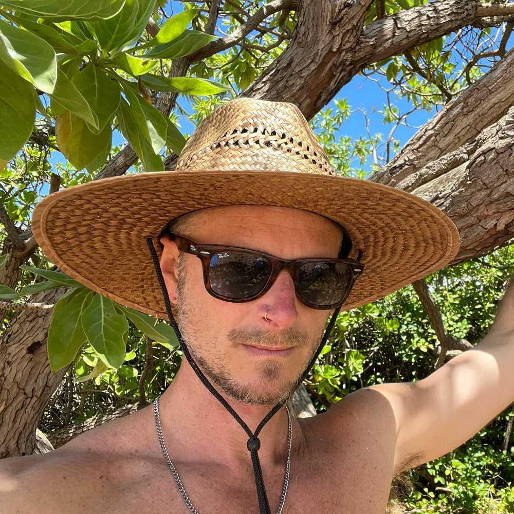 Male model styling front view of Sundaze Palm Straw Sun Hat, demonstrating unisex natural sun hat.