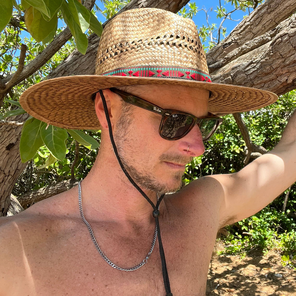 Male model styling square crop profile view of Sundaze Palm Straw Sun Hat, demonstrating unisex natural sun hat.