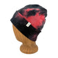 A black and red tie-dye knit beanie hat displayed on a wooden mannequin head against a white background.