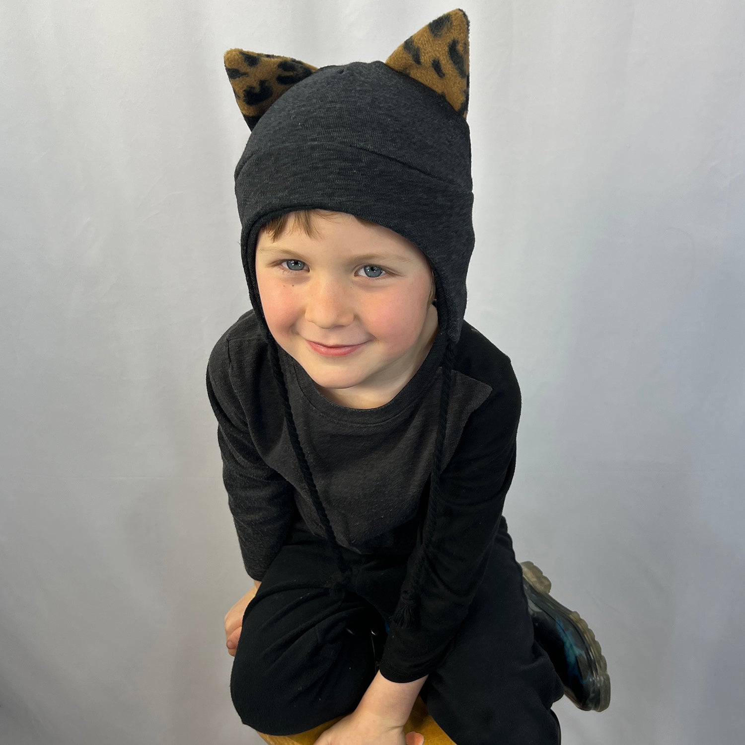 Wildkat Beanie in Black Deep Space color way, front view of kid model – fun kids fleece hat with ears by G & L Positive Goods