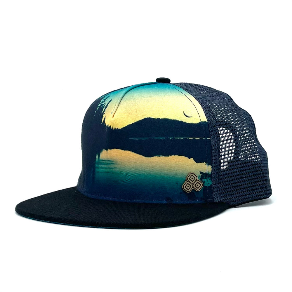 Unisex low-profile trucker hat. Graphic print image of Juniper Lake at Lassen National Park. Adjustable snap with mesh back.