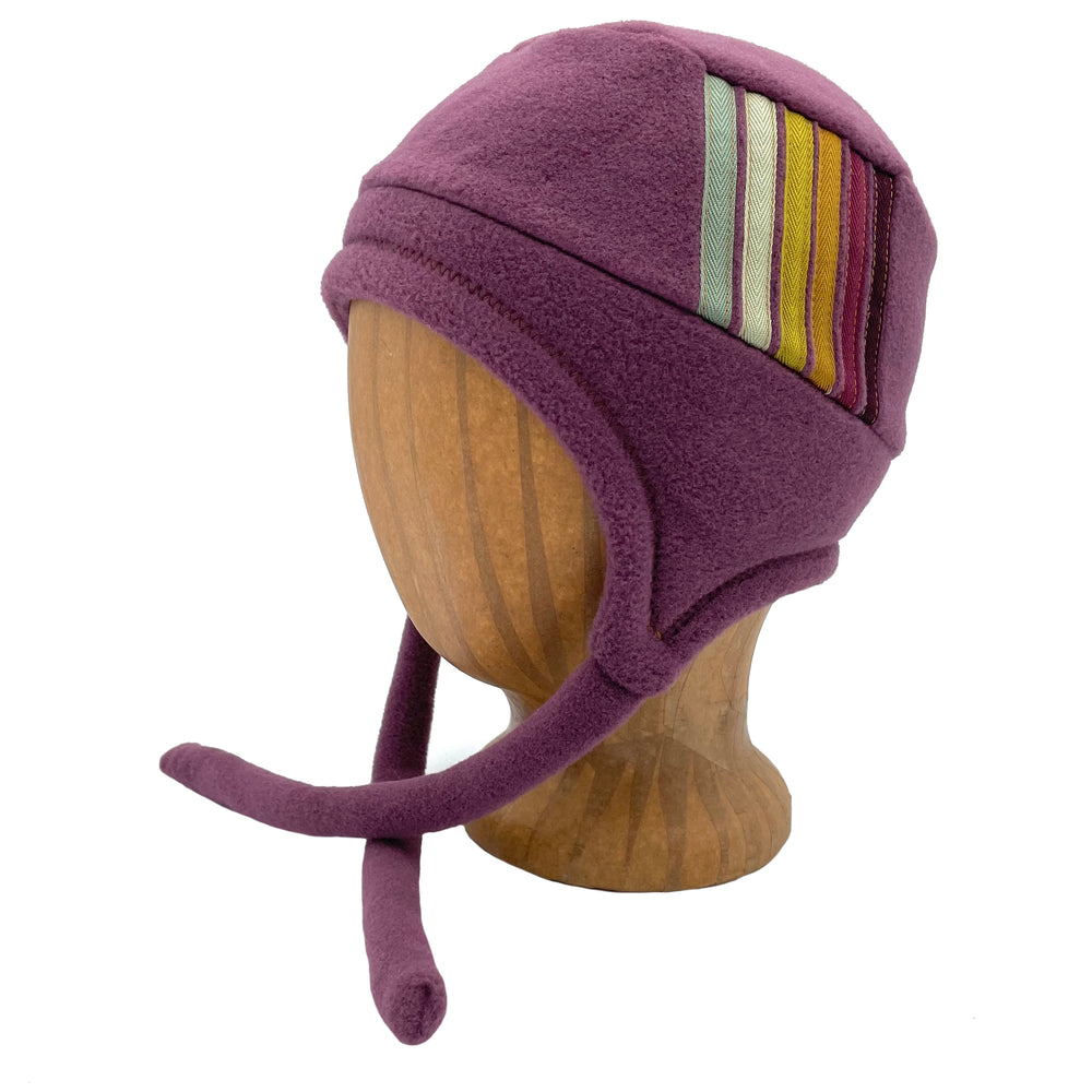 Colorful kids hat with ear flaps and chin straps. Made in the USA from Polartec fleece. Shop sustainable hats. *plum wine